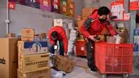 Xu Guobin dan rekan-rekannya mencatat paket di Xi'an, Provinsi Shaanxi, China barat laut, pada 3 Februari 2020. Dipengaruhi oleh merebaknya wabah coronavirus baru, Xu harus mengantarkan paket tiga kali lebih banyak dibandingkan beberapa tahun terakhir. (Xinhua/Liu Xiao)