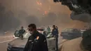 Lebih dari 250 petugas pemadam kebakaran, termasuk 46 unit mobil, tiga truk, lima helikopter, enam ambulans paramedis, serta pihak terkait lainnya berada di lokasi sambil terus berupaya memadamkan kebakaran Palisades. (Apu Gomes/Getty Images North America/Getty Images via AFP)