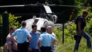 Aparat kepolisian berdiri dekat helikopter yang ditinggalkan seorang gangster terkenal Prancis, Redoine Faid di Gonesse, utara Paris, Minggu (1/7). Faid (46) kabur dari penjara di Reau dengan dijemput helikopter tersebut. (AFP/GEOFFROY VAN DER HASSELT)