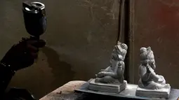 Seorang perajin mengerjakan pembuatan patung Dewa Ganesha di sebuah bengkel di Mumbai, India, 24 Agustus 2021. Pembuatan patung dewa Hindu berkepala gajah tersebut dilakukan jelang Festival Ganesh Chaturthi. (SUJIT JAISWAL/AFP)