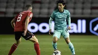Gelandang Liverpool, Takumi Minamino, berebut bola dengan gelandang Lincoln City, James Jones, pada laga babak ketiga Piala Liga Inggris di Sincil Bank Stadium, Jumat (25/9/2020). Liverpool menang telak 7-2 atas Lincoln. (AFP/Peter Powell/pool)
