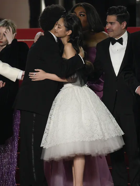 <p>Abel Tesfaye dan Jennie berbagi berpelukan jhangat setibanya di pemutaran perdana The Idol. Jennie mengenakan gaun selutut berbahan lace putih yang dipercantik dengan aksen hitam. (AP Photo/Daniel Cole)</p>