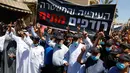 Warga berorasi mengenakan masker saat menggelar aksi protes terhadap keputusan pemerintah soal penggusuran di kota pesisir Mediterania, Jaffa, Tel Aviv selatan (26/6/2020). (AFP Photo/Jack Guez)