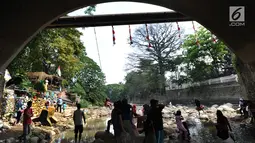 Warga bermain di kolong jembatan Sempur, Bogor (16/9). Musim kemarau yang menyebabkan debit Sungai Ciliwung menyusut drastis dimanfaatkan warga Bogor dan sekitarnya untuk berwisata murah dan gratis di aliran sungai. (Merdeka.com/Arie Basuki)