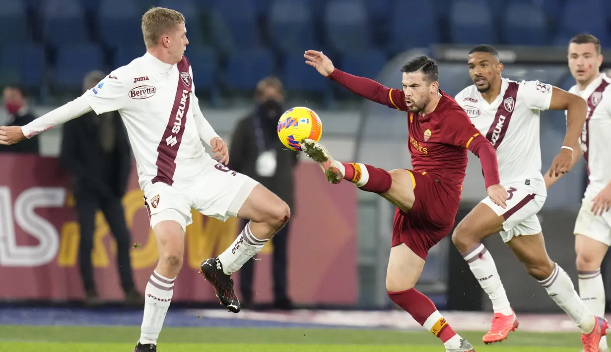 Penyerang AS Roma, Carles Perez berebut bola dengan bek Torino, David Zima pada pertandingan lanjutan Liga Serie A Italia di stadion Olimpiade Roma, Senin (29/11/2021). Roma menang tipis atas Torino 1-0. (AP Photo/Gregorio Borgia)