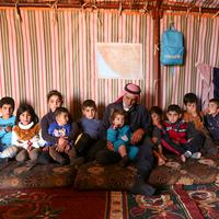 Abderrazaq Khatoun, beristirahat dengan 11 cucunya yang yatim piatu di dalam tenda di desa Harbanoush, di Idlib, Suriah pada 11 Maret 2021. Perang Suriah yang merampas 13 anak Khatoun dan salah satu istrinya, membuat kakek 83 tahun itu membesarkan 11 cucu yatim piatu sendirian. (Ahmad al-ATRASH/AFP)