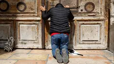 Seorang peziarah berdoa di gerbang Gereja Makam Kudus di Kota Tua Yerusalem, Minggu (25/2). Para pemimpin Kristen mengambil langkah langka untuk menutup gereja yang menjadi tempat di mana Yesus disalibkan, wafat, dimakamkan, dan bangkit. (GALI TIBBON/AFP)