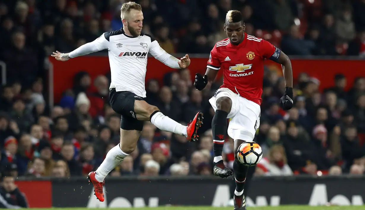 Pemain Manchester United, Paul Pogba (kanan) berusaha melewati adangan pemain Derby County, Johnny Russell pada laga PIala FA di Old Trafford, Manchester, (5/1/2018). Manchester United menang 2-0. (Martin Rickett/PA via AP)