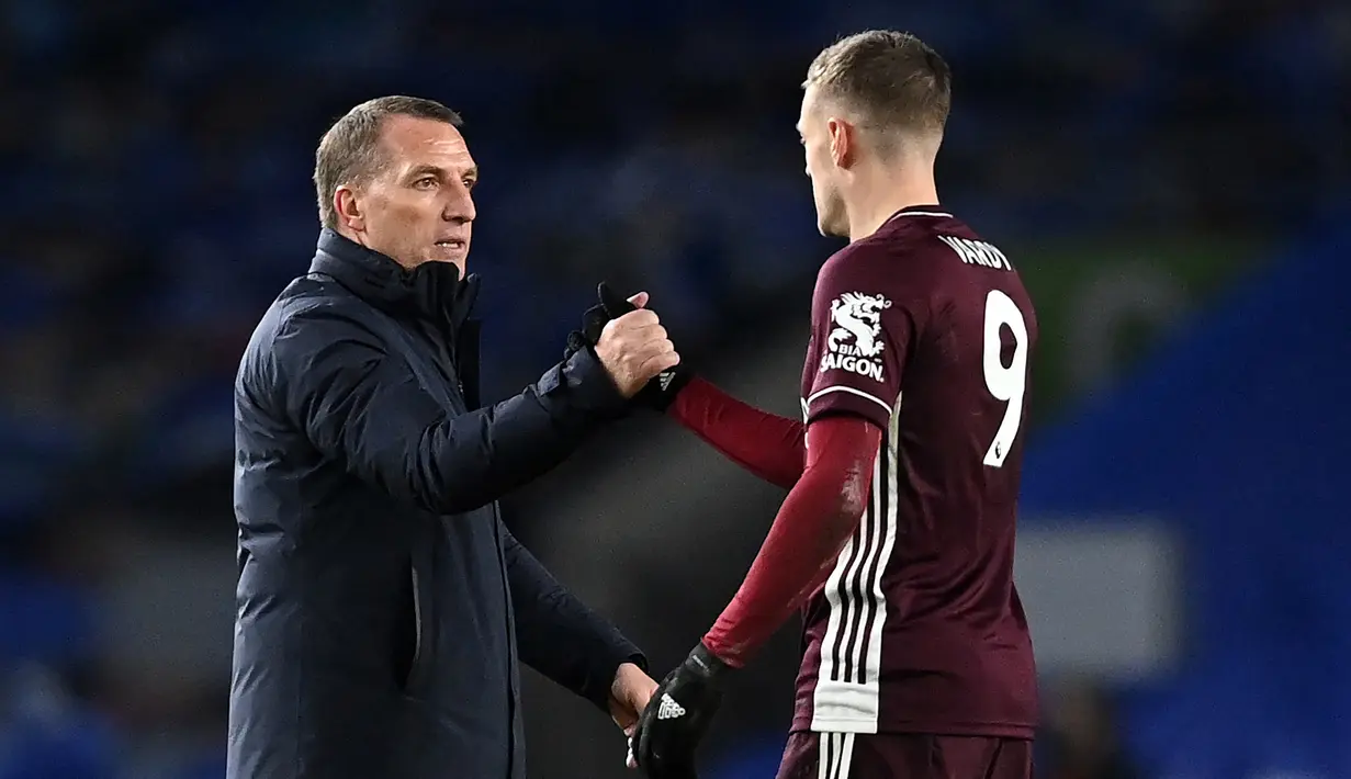 Manajer tim Leicester City, Brendan Rodgers (kiri) menyalami striker Jamie Vardy usai berakhirnya laga lanjutan Liga Inggris 2020/21 melawan Brighton and Hove Albion, Minggu (7/3/2021). Leicester City menang 2-1 atas Brighton. (AFP/Neil Hall/Pool)
