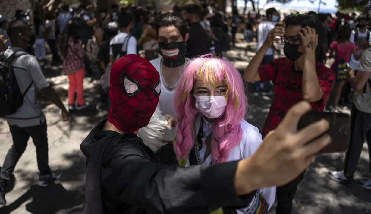<p>Penggemar anime dan video game Kuba berpakaian seperti pahlawan atau karakter favorit mereka, berpose untuk selfie selama parade Cosplay di sela-sela Pameran Buku Internasional Havana, di Havana, Sabtu (23/4/2022). (AP Photo/ Ramon Espinosa)</p>