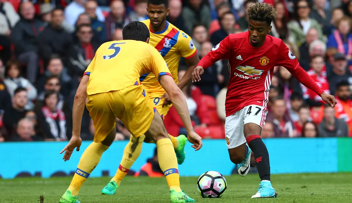 Gelandang Manchester United, Angel Gomes, berusaha melewati bek Crystal Palace, James Tomkins, pada laga Premier League di Stadion Old Trafford, Inggris, Minggu (21/5/2017). MU menang 2-0 atas Palace. (EPA/Tim Keeton)