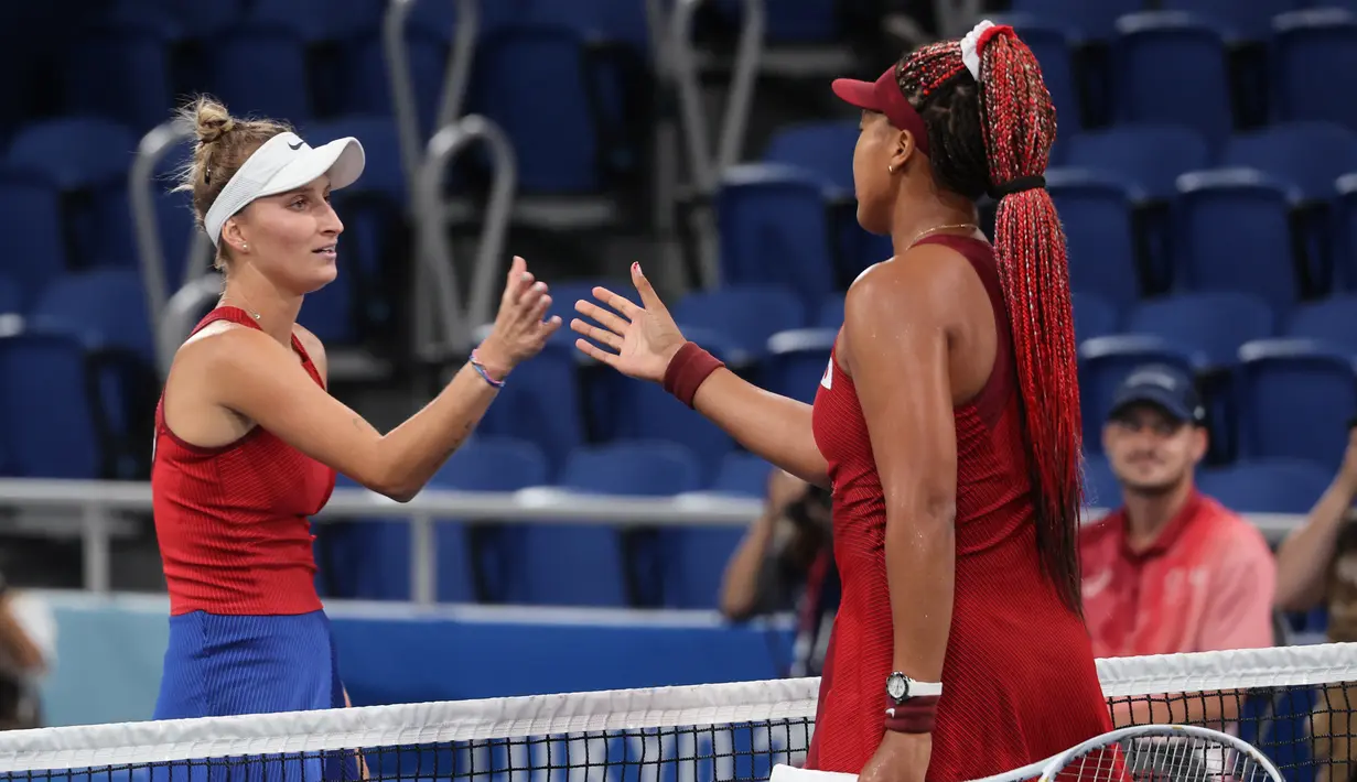 Petenis Jepang Naomi Osaka bersalaman dengan dikalahkan Marketa Vondrousova dari Republik Ceko usai pertandingan tenis putaran ketiga tunggal putri Olimpiade Tokyo 2020 di Ariake Tennis Park di Tokyo (27/7/2021). Vondrousova yang berada di peringkat ke-42 sukses mengalahkan Noami. (AFP/Tiziana Fabi)