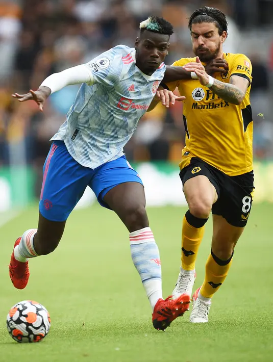 Gelandang Wolverhampton Wanderers Ruben Neves (kanan) berebut bola gelandang Manchester United (MU) Paul Pogba pada match day ketiga Liga Inggris di Stadion Molineux, Minggu (29/8/2021). MU menang tipis 1-0 lewat gol Mason Greenwood. (Oli SCARFF/AFP)