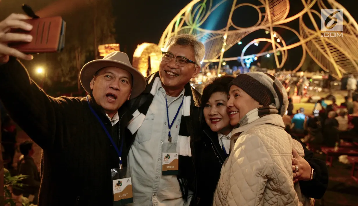 Gubernur Bank Indonesia, Agus Martowardoyo (kiri) dan Bupati kabupaten Malang, Rendra Kresna (dua kiri) beserta istri, berswafoto pada pagelaran Jazz Gunung 2018 di Kawasan Gunung Bromo, Jawa Timur, Jumat (27/7). (Liputan6.com/HO/Ridhwan Siregar)