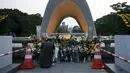 Seorang wanita berdoa untuk para korban bom atom di depan cenotaph pada saat peringatan 70 tahun jatuhnya bom atom di Hiroshima, Jepang (6/8/2015). 140.000 penduduk Jepang tewas akibat Bom Atom. (REUTERS/Toru Hanai)