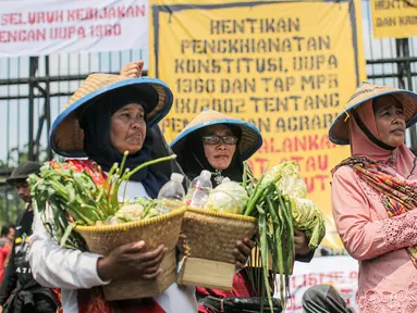 Sejumlah elemen masyarakat yang tergabung dalam buruh dan petani menggelar aksi di depan Gedung DPR, Jakarta, Selasa (27/9/2022). Aksi tersebut digelar tepat di momentum peringatan Hari Tani Nasional (HTN) 2022, 27 September. (Liputan6.com/Faizal Fanani)