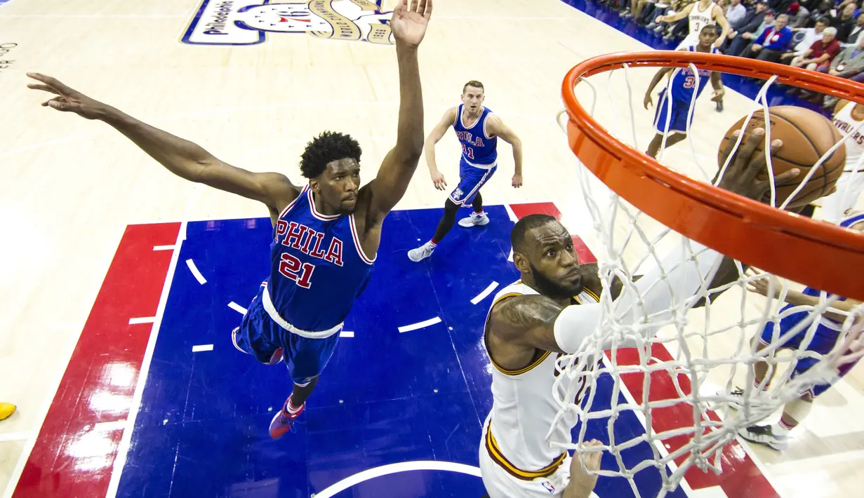 Pemain Cleveland Cavaliers, LeBron James (kanan), melewati pemain Philadelphia 76ers, Joel Embiid, untuk mencetak angka dalam laga NBA di Philadelphia, (5/11/2016). (AP Photo/Chris Szagola)