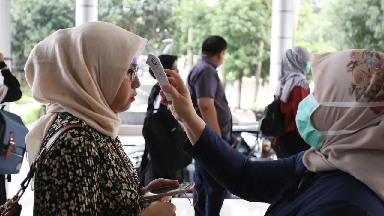 Petugas kesehatan memeriksa suhu tubuh seluruh pekerja dan tamu yang akan masuk ke Kantor Pusat Pertamina di Jalan Merdeka Timur Jakarta. (Dok Pertamina)