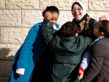 Seorang guru dengan Down Syndrome yang bernama Hiba Al-Sharfa bermain dengan muridnya di sekolah Asosiasi Hak Hidup di Kota Gaza (21/12). Hiba adalah seorang guru yang memeliki “kebutuhan khusus” di Jalur Gaza. (Reuters/Suhaib Salem)