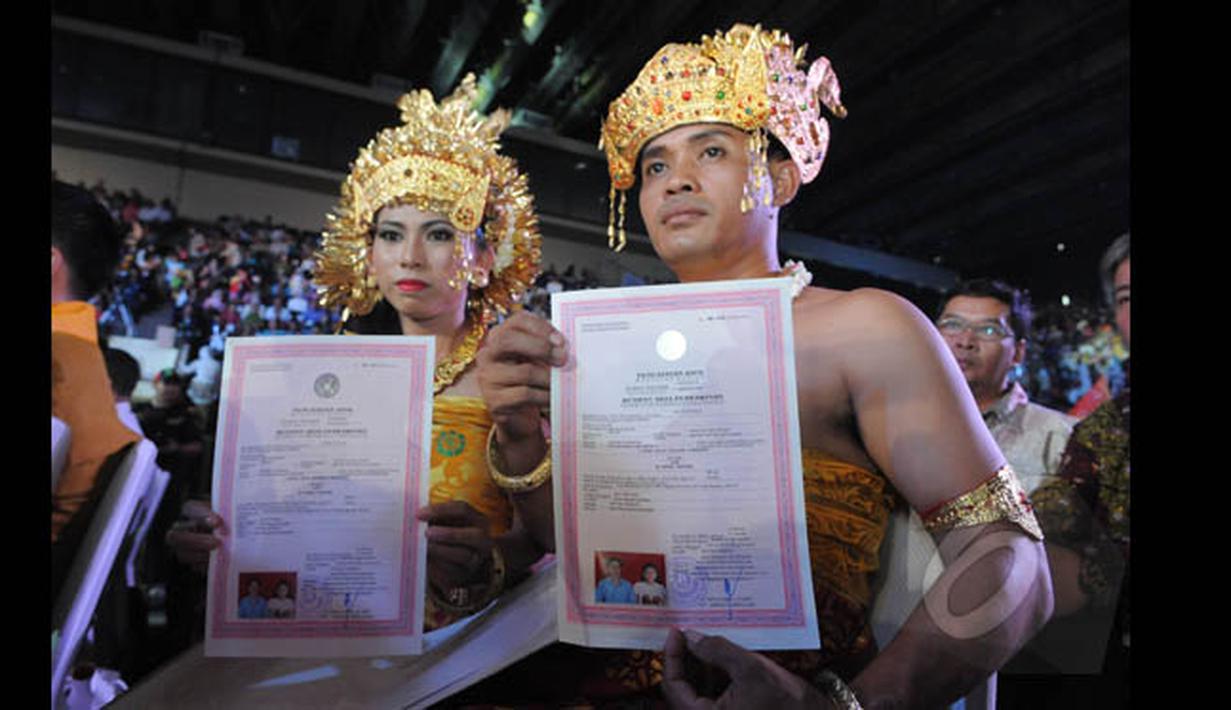 Sepasang pengantin memperlihatkan surat nikah saat mengikuti Resepsi Penikahan Massal Pengantin se-Jabodetabek di Istora Senayan, Jakarta, Rabu (28/1/2015). (Liputan6.com/Herman Zakharia)