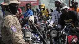 Pengendara sepeda motor mencoba masuk ke dalam pompa bensin saat terjadi kelangkaan bahan bakar nasional di Port-au-Prince, Haiti, Minggu (31/10/2021). Kelangkaan BBM membuat warga Haiti sulit mendapatkan transportasi dan memaksa sejumlah bisnis menghentikan operasi. (AP Photo/Matias Delacroix)