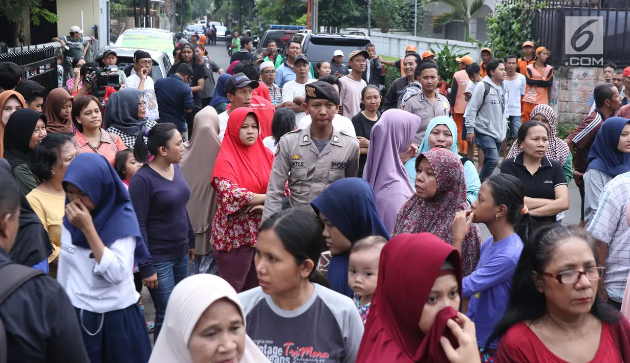 Kerumunan warga di depan lokasi pembunuhan wanita yang ditemukan tewas di dalam lemari di kawasan Mampang, Jakarta, Jumat (23/11). Polres Jaksel menggelar rekonstruksi setelah penyidik menggali keterangan pelaku. (Liputan6.com/Helmi Fithriansyah)