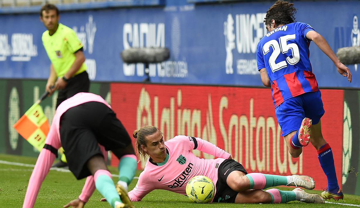 Penyerang Barcelona, Antoine Griezmann, berusaha menghadang gelandang Eibar, Bryan Gil, pada laga Liga Spanyol di Stadion Ipurua, Sabtu (23/5/2021). Barcelona menang dengan skor 1-0. (AFP/Ander Gillenea)