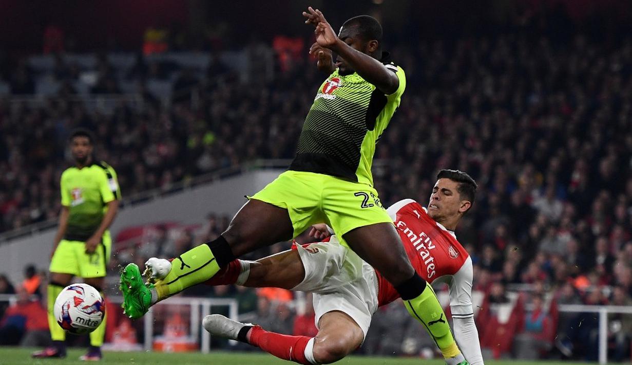 Pemain Arsenal,  Gabriel Paulista, berebut bola dengan pemain Reading, Danzell Gravenberch, dalam laga 16 besar Piala Liga Inggris di Stadion Emirates, Rabu (26/10/2016) dini hari WIB. (Reuters/Dylan Martinez)