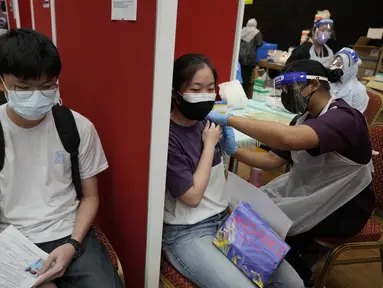 Seorang siswa sekolah menengah menerima dosis vaksin Pfizer terhadap penyakit coronavirus (COVID-19) di pusat vaksin di Shah Alam, Malaysia, Senin (20/9/2021). (AP Photo/Vincent Thian)