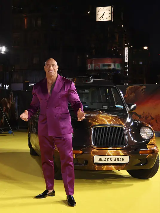 Dwayne Johnson berpose untuk fotografer saat tiba pada pemutaran perdana film 'Black Adam' di London, Inggris, 18 Oktober 2022. Aktor berusia 50 tahun itu bertelanjang dada di bawah pakaian two-piece. (Photo by Vianney Le Caer/Invision/AP)