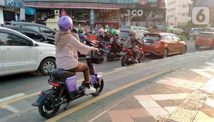 Warga mengendarai sepeda listrik saat berkeliling di jalur sepeda kawasan Kebun Raya Bogor, Kota Bogor, Jawa Barat, Minggu (25/9/2022). Pembiasaan penggunaan transportasi listrik dilakukan untuk menuju transportasi ramah lingkungan atau transportasi hijau. (Liputan6.com/Magang/Aida Nuralifa)