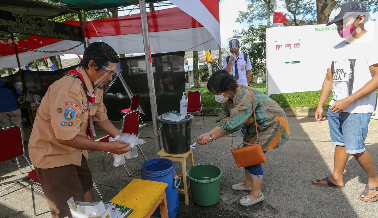 Warga mencuci tangan sebelum melakukan pemungutan suara pada Pilkada Tangerang Selatan di TPS 49 Cendana Residence, Pondok Benda, Pamulang, Rabu (9/12/2020). TPS 49 pada Pilkada Serentak 2020 mengusung tema Rindu Sekolah Lagi (Kisah-Kasih di Sekolah). (Liputan6.com/Fery Pradolo)