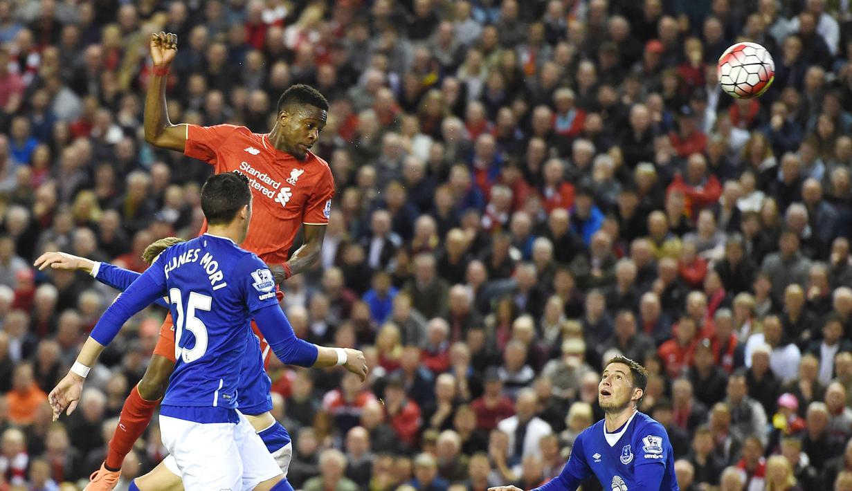 Pemain Liverpool, Divock Origi (kanan), menyundul bola melewati hadangan pemain Everton pada lanjutan Liga Inggris di Stadion Anfield, Liverpool, Kamis (21/4/2016) dini hari WIB. (AFP/Paul Ellis)