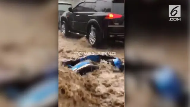 Video amatir menampilkan sebuah sepeda motor terseret arus banjir di kawasan Cipanas, Puncak, Jawa Barat.