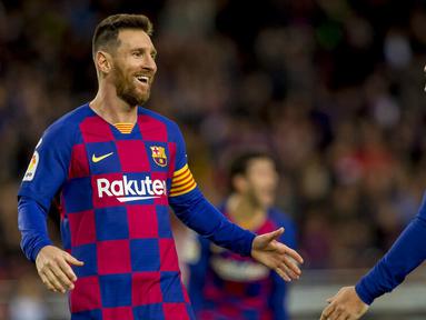 Striker Barcelona, Lionel Messi, melakukan selebrasi bersama Antoine Griezmann usai membobol gawang Deportivo Alaves pada laga La Liga 2019 di Stadion Camp Nou, Sabtu (21/12). Barcelona menang 4-1 atas Alaves. (AP/Joan Monfort)