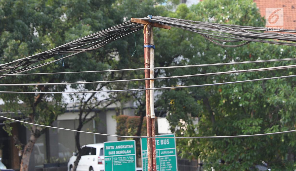 Tiang bambu menyangga instalasi kabel di kawasan Pasar Baru, Jakarta, Selasa (12/9). Selain membahayakan pengguna jalan, buruknya instalasi kabel tersebut juga merusak estetika kota. (Liputan6.com/Immanuel Antonius)