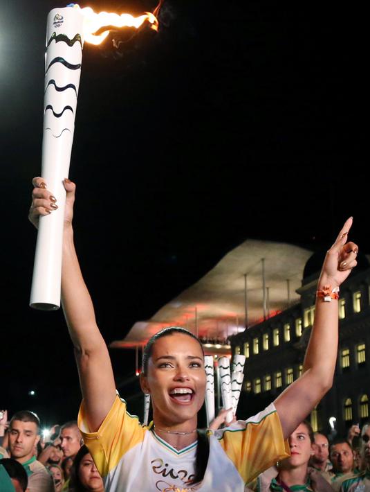 Senyum semringah supermodel Adriana Lima ketika membawa obor pada malam penyambutan Olimpiade Rio 2016 di Maua Square Rio de Janeiro, Brasil, Kamis (4/8). (REUTERS / Pilar Olivares)
