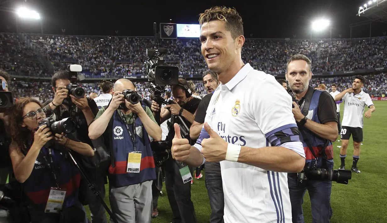 Bintang Real Madrid, Cristiano Ronaldo dikerubuti wartawan saat merayakan gelar juara La Liga Spanyol usai menaklukkan Malaga di Stadion La Rosaleda, Malaga, Minggu (21/5/2017). Malaga kalah 0-2 dari Madrid. (EPA/Daniel Perez)