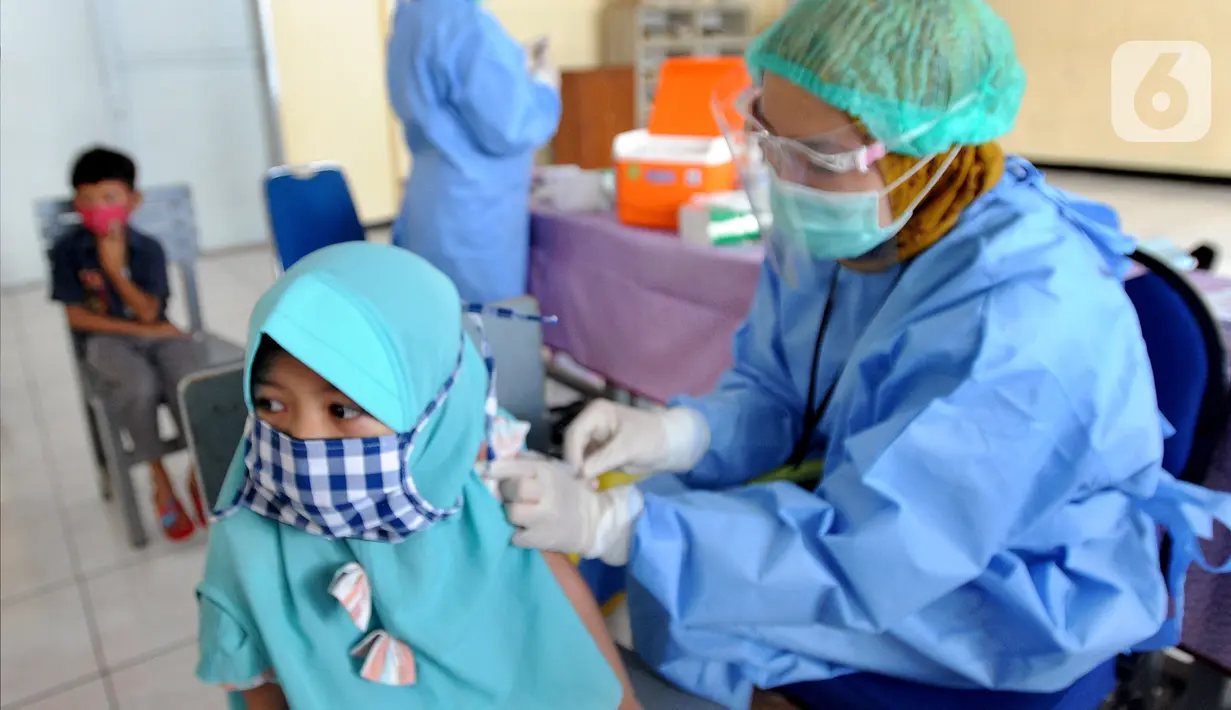 Petugas kesehatan menyuntikkan vaksin tetanus difteri ke siswa kelas 1 di SDI Al Hidayah, Cinere, Depok, Jumat (20/11/2020). Program imunisasi kepada pelajar di Kota Depok terus berjalan guna menjaga kesehatan anak dan meningkatkan imunitas tubuh di masa pandemi COVID-19. (merdeka.com/Arie Basuki)