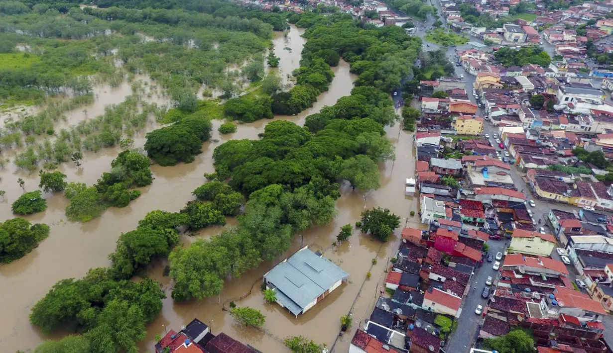 Pemandangan dari udara banjir akibat hujan lebat di Itapetinga, Negara Bagian Bahia, Brasil, 26 Desember 2021. Hujan lebat yang mengguyur Bahia telah menyebabkan lebih dari 4 ribu rumah terdampak dan menyulitkan akses sejumlah masyarakat. (Manuella LUANA/AFP)
