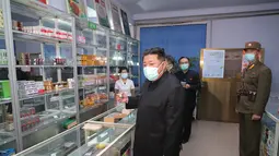 Pemimpin Korea Utara Kim Jong Un mengenakan masker memeriksa apotek di tengah wabah Covid-19 di Pyongyang, Korea Utara pada 15 Mei 2022. Korea Utara telah memobilisasi militernya untuk mendistribusikan obat-obatan COVID dan mengerahkan lebih dari 10.000 petugas kesehatan untuk membantu melacak pasien potensial terkena Covid-19. (STR/KCNA VIA KNS/AFP)