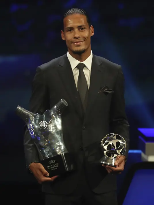Bek Liverpool Virgil van Dijk memegang piala penghargaan Pemain Terbaik Eropa 2018-2019 selama undian babak grup di Grimaldi Forum, Monako, Kamis (29/8/2019). Virgil van Dijk berhasil mengungguli Lionel Messi dan Cristiano Ronaldo. (AP Photo/Daniel Cole)