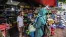 Marsyaad atau biasa dipanggil Pak Umar (79) melayani pembeli di toko mainan miliknya di Kalibata, Jakarta, Kamis (25/2/2021). Kendati pandemi COVID-19, Pak Umar yang mulai bisnis bermodal Rp 800 bahkan bisa mengirim mainan anak buatannya ke beberapa wilayah di Jawa. (Liputan6.com/Johan Tallo)