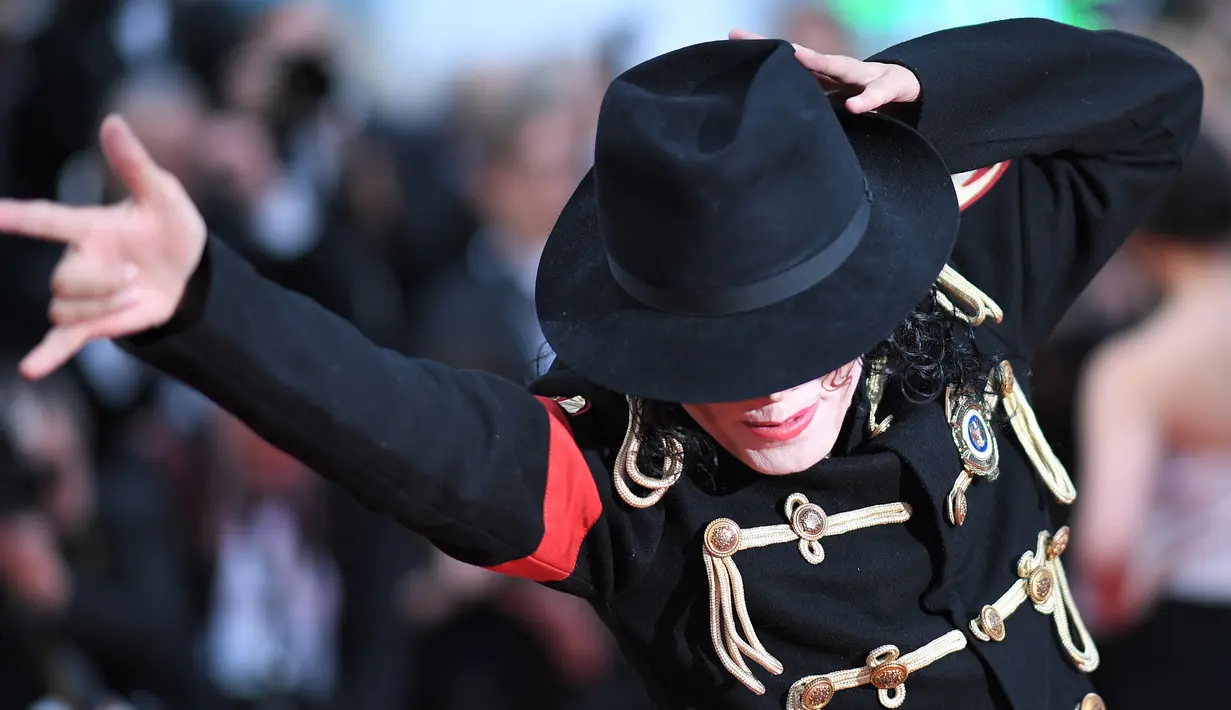 Pria berpenampilan Michael Jackson berpose setibanya di karpet merah  pemutaran film Solo: A Star Wars Story pada Festival Film Cannes, Prancis, Selasa (15/5). Kehadiran pria mirip mendiang raja musik pop dunia itu mengundang perhatian. (AFP/LOIC VENANCE)