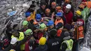 Haci Murat Kilinc dibawa melewati kerumunan dengan tandu setelah dia diselamatkan di bawah bangunan yang hancur di Iskenderun, Turki tenggara, Jumat (10/2/2023). Pasangan suami istri ditarik dari bawah puing-puing bangunan yang runtuh di Iskenderun setelah menghabiskan 109 jam terkubur di dalam celah kecil. (AP Photo/Petros Giannakouris)