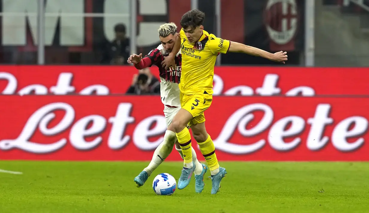 Bek AC Milan, Theo Hernandez berusaha merebut bola dari pemain Bologna, Aaron Hickey pada pertandingan lanjutan Liga Serie A Italia di stadion San Siro, di Milan, Italia, Selasa (5/4/2022). AC Milan bermain imbang atas Bologna 0-0. (AP Photo/Antonio Calanni)
