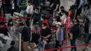 Orang-orang mengantre check-in untuk penerbangan domestik menjelang liburan "Golden Week" di Bandara Internasional Ibu Kota Beijing pada 30 September 2020. Gelombang liburan melanda China yang warganya merayakan libur panjang, yang dikenal dengan Golden Week. (NICOLAS ASFOURI / AFP)