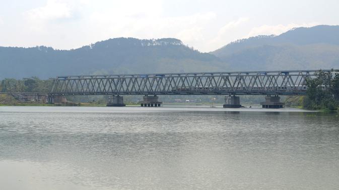 Sebuah kereta melintas di jembatan Sungai Serayu, Rawalo, Banyumas, Jawa Tengah. (Liputan6.com/Muhamad Ridlo)