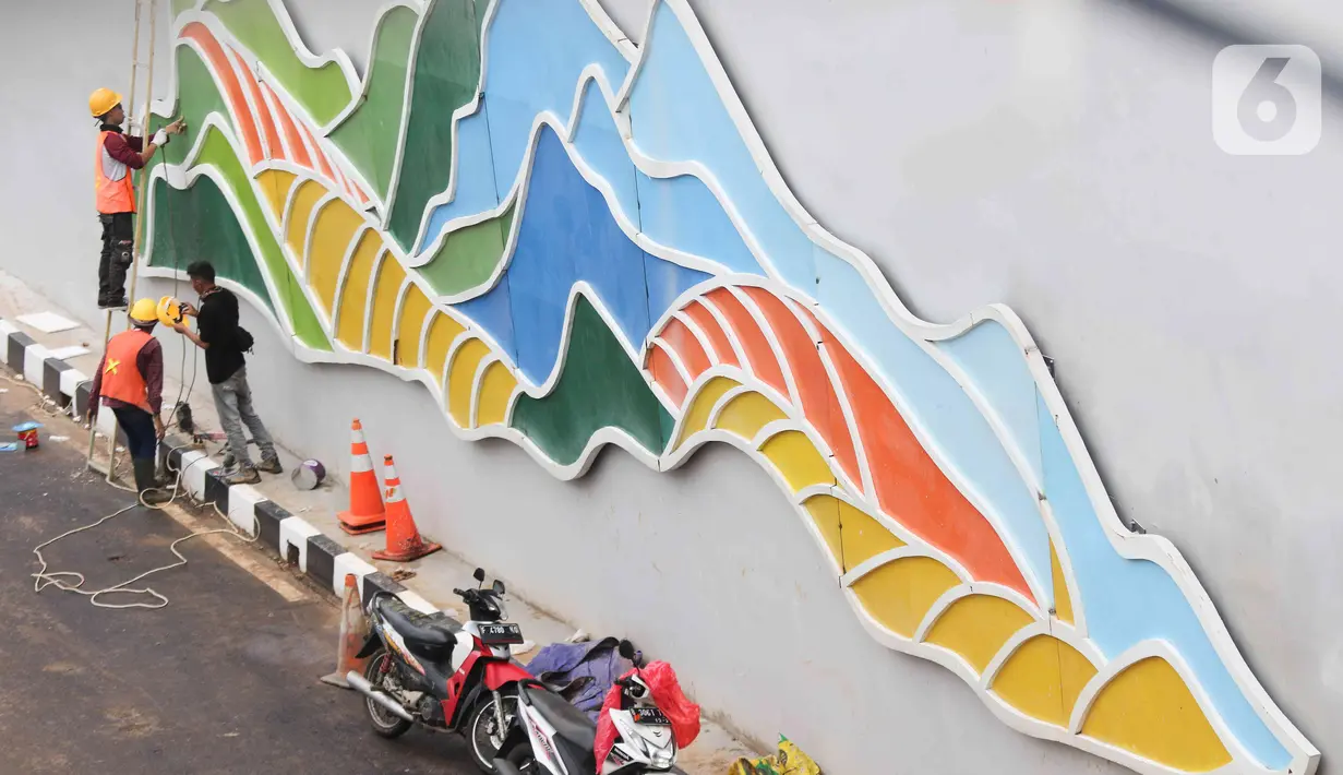Pekerja menyelesaikan proyek pembangunan Underpass Jalan Dewi Sartika di Depok, Jawa Barat, Selasa (3/1/2023). Pembangunan underpass Jalan Dewi Sartika sepanjang 470 meter tersebut itu masih terdapat beberapa hal yang belum terselesaikan seperti trotoar, median jalan, dan pepohonan yang sebelumnya direncanakan akan selesai pada akhir tahun 2022. (Liputan6.com/Herman Zakharia)