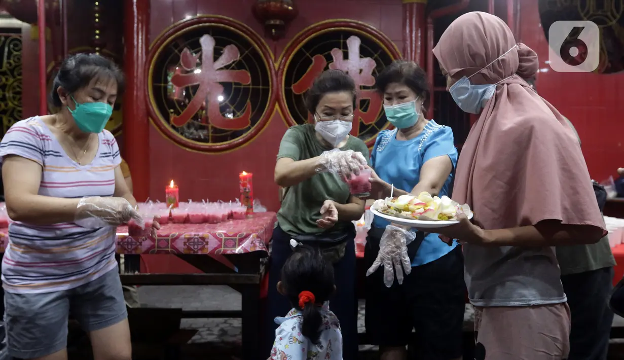 Warga menerima makanan berbuka puasa di Vihara Dharma Bhakti, Petak Sembilan, Jakarta, Kamis (7/4/2022). Yayasan Vihara Dharma Bhakti menyediakan sekitar 200 porsi menu berbuka puasa bagi warga sekitar untuk lebih mempererat persaudaraan umat beragama. (Liputan6.com/Helmi Fithriansyah)
